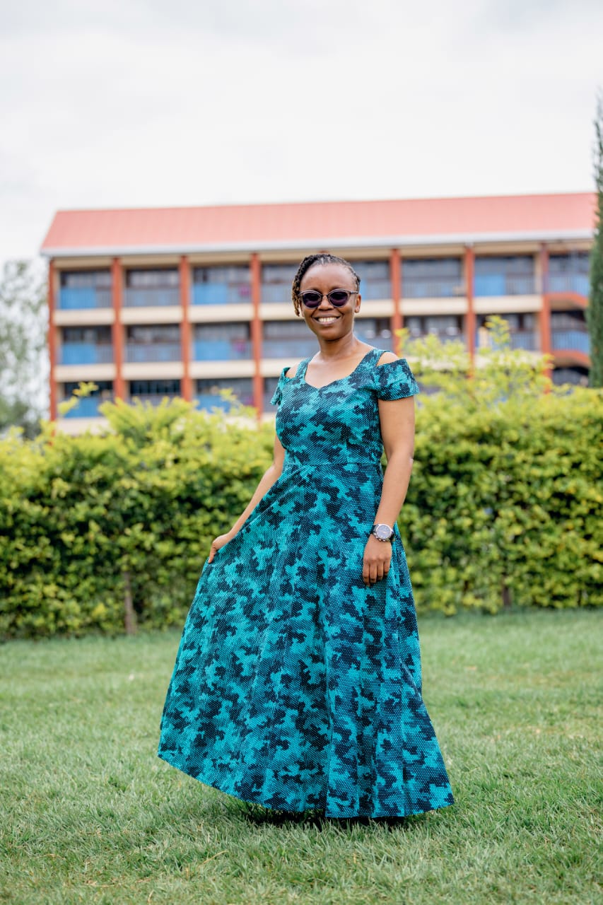 Emma Karuri, founder of CalmFriction, sitting on a vintage car