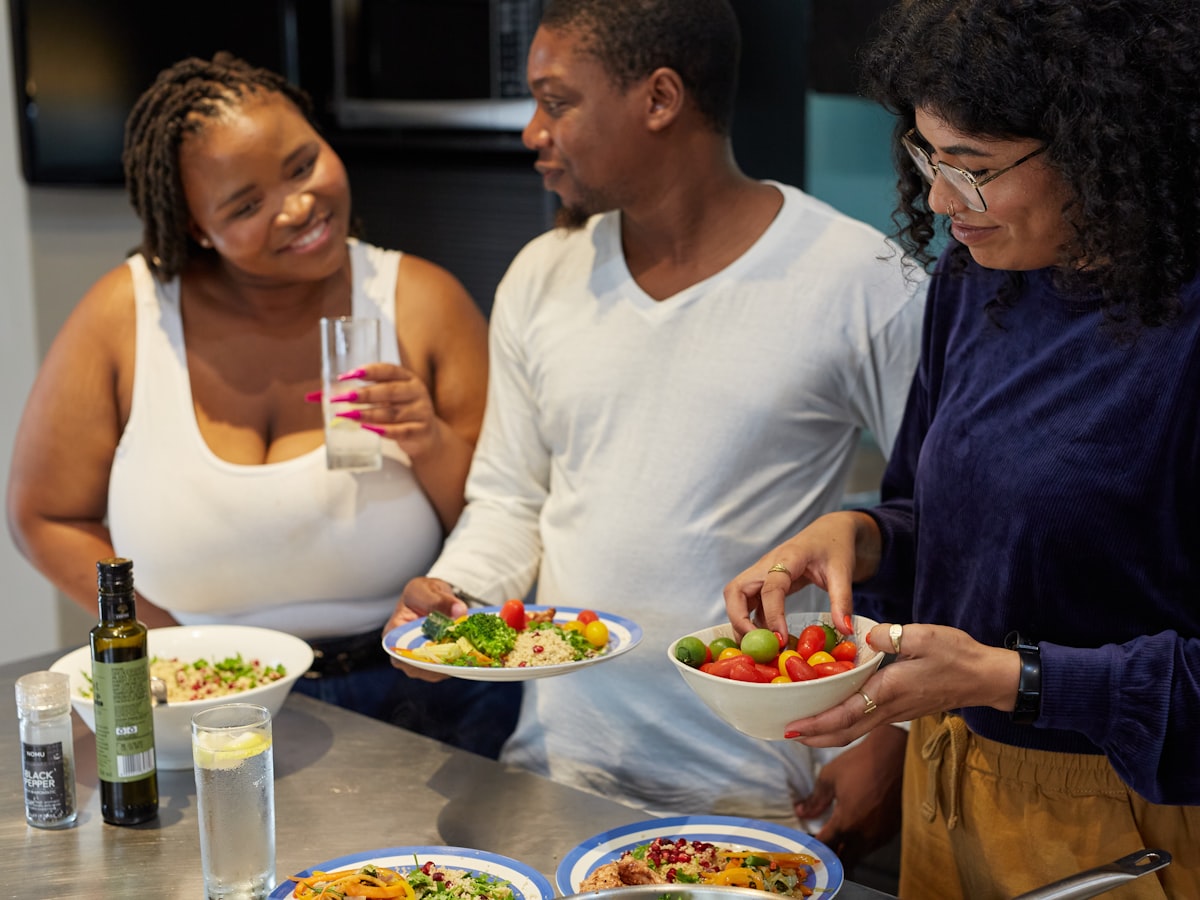 A group of people preparing and sharing a meal together in a kitchen